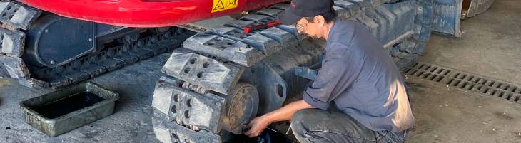 Technician checking track tension