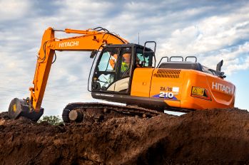 A Hitachi/Landcros ZX210 excavator working on top of a dirt pile