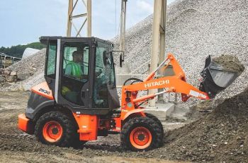A Hitachi/Landcros ZW30 compact wheel loader lifting a bucket of gravel