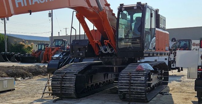 A Hitachi/Landcros excavator parked beside a service truck