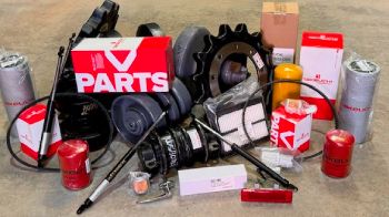 Filters, a sprocket, hydraulic hoses, and a parts box laid out on the floor