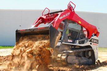 A Takeuchi TL12V2 track loader pushing a full bucket of dirt