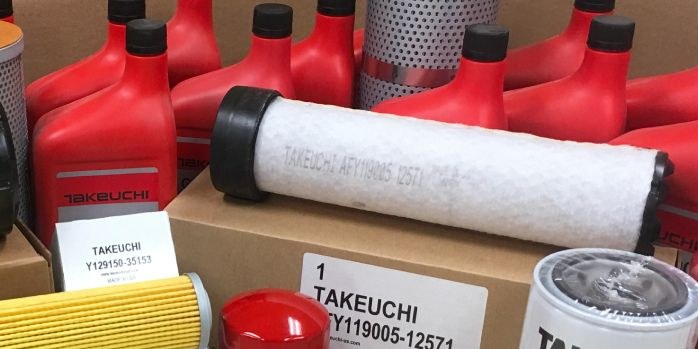 Takeuchi filters and oil in boxes on a parts shelf