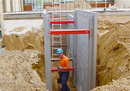An aluminum trench box set in a trench with a worker inside